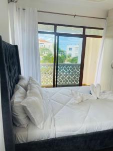 - une chambre avec un lit et une vue sur l'océan dans l'établissement Lux Suites 2 Bedroom Sultan Palace Apartments, à Kikambala