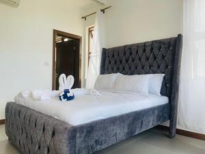 un lit avec un lapin rembourré assis au-dessus dans l'établissement Lux Suites 2 Bedroom Sultan Palace Apartments, à Kikambala