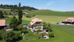 an aerial view of a house in a green field at Like on cloud nine - Apartment in Emmental 