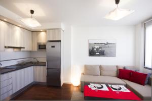een woonkamer met een bank en een keuken bij Apartment Livemálaga Victoria in Málaga