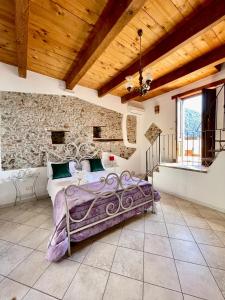 a bedroom with a bed and a stone wall at La Magara in Civita