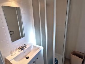biała łazienka z umywalką i prysznicem w obiekcie LA LEGERE - 500m de la Mer w mieście Jard-sur-Mer