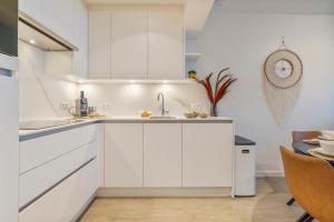 una cocina con armarios blancos y fregadero en Seagusta - sea view apartment in Middelkerke, en Middelkerke