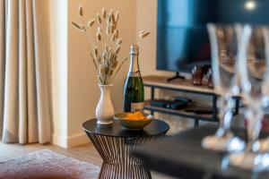 una mesa con una botella de vino y un jarrón en Seagusta - sea view apartment in Middelkerke, en Middelkerke