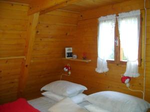 a bedroom with two beds in a log cabin at Baita Giggia sulle piste - Cavalese in Trentino Alto Adige cottage chalet in Cavalese
