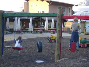 a woman and a little girl playing in a playground at Baita Giggia sulle piste - Cavalese in Trentino Alto Adige cottage chalet in Cavalese