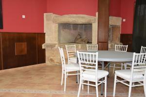 una mesa y sillas en una habitación con chimenea en HOTEL LOS CAÑAS, en Iniesta