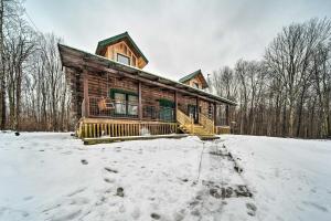 a log cabin in the woods in the snow at Cabin in Lake Chautauqua on 36 Acres with Hot Tub! in Ashville