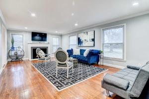 a living room with a blue couch and a fireplace at Luxurious Detroit Home - Walk to Golf and Park! in Detroit