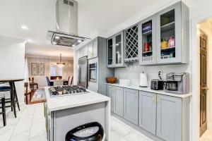 a kitchen with white cabinets and a stove top oven at Luxurious Detroit Home - Walk to Golf and Park! in Detroit