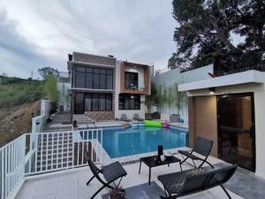 Private Resthouse with Cozy Pool and Nice View في أنتيبولو: بيت فيه مسبح قدام بيت