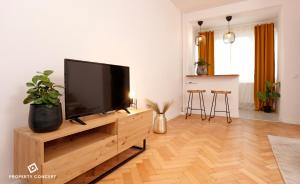 sala de estar con TV de pantalla plana en un centro de entretenimiento de madera en The Pearl of Drumul Taberei + Netflix, en Bucarest