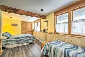 2 camas en una habitación con paredes y ventanas amarillas en Cozy Waterfront Cottage on Montsweag Bay!, en Westport