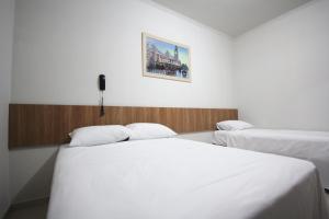 1 dormitorio con 2 camas y una foto en la pared en Pousada Esmeralda Olímpia, en Olímpia