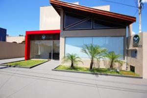 a building with large windows and palm trees in front of it at Pousada Esmeralda Olímpia in Olímpia