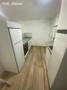 a kitchen with white appliances and a wooden floor at Casa Sergio in Madrid