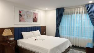 a bedroom with a bed with blue curtains and a window at Tam Coc Center Boutique Hotel in Ninh Binh