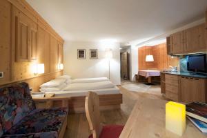 a hotel room with a bed and a couch at Residence Mugun in Corvara in Badia
