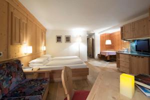 une chambre d'hôtel avec un lit et un canapé dans l'établissement Residence Mugun, à Corvara in Badia