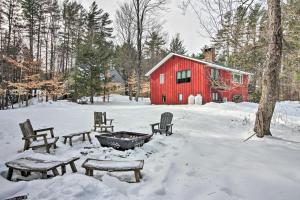 a fire pit and benches in the snow in front of a red barn at Inviting Vermont Cabin On Mount Ascutney! in Brownsville