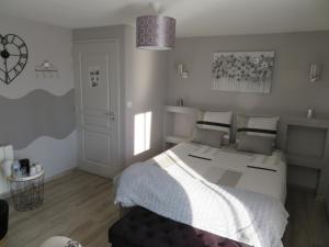 a bedroom with a bed with a white comforter at Chambres d'Hotes La Maison Neuve in Saint-Loup