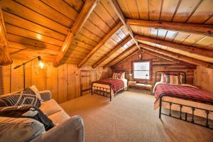 una sala de estar con 2 camas en una cabaña de madera en Cambridge Springs Cabin Near French Creek!, en Cambridge Springs