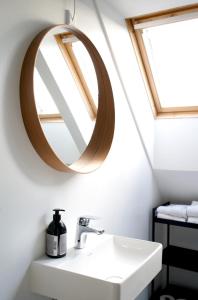 W łazience znajduje się umywalka i lustro. w obiekcie Kirsebærkroen - The Inn Between w mieście Præstø