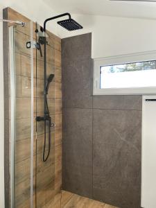 La salle de bains est pourvue d'une douche avec une porte en verre. dans l'établissement Modernes Tinyhouse Trailer Cabins am Waldrand - mit Seezugang, à Eging am See