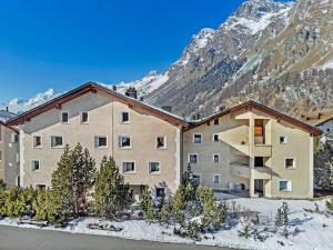 an apartment building in the mountains with snow at Abitaziun Cravunera - Sils Maria in Sils Maria