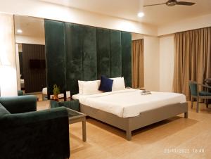 a bedroom with a bed and a green wall at Morpho Bokaro in Bokāro