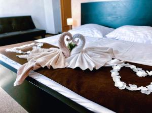 two swans are sitting on a bed at Hotel Modena in Bratislava