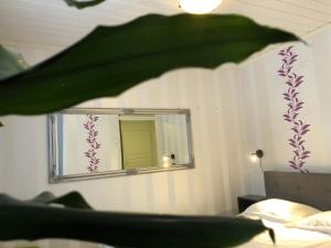 a mirror on a wall in a bedroom with a bed at Kiviharjun B&B in Kotka