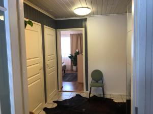 a hallway with a green chair in a room at Kiviharjun B&B in Kotka