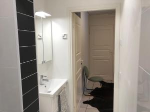 a bathroom with a sink and a chair next to a door at Kiviharjun B&B in Kotka +1 photo