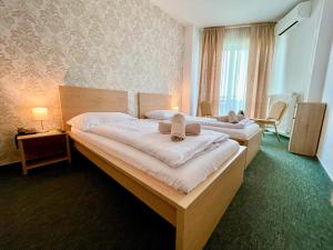 a hotel room with two beds with towels on them at Hotel Modena in Bratislava