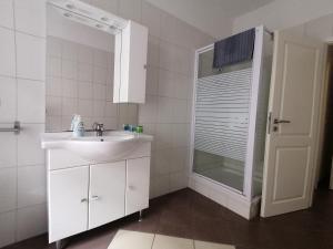 a white bathroom with a sink and a shower at Pension Gina in Görlitz