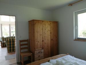 a bedroom with a wooden cabinet and a bed at Ferienhaus Brise Ostsee in Kalkhorst