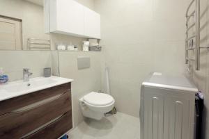 a white bathroom with a toilet and a sink at Seine Apartment by Downtown Inn, City Center in Yerevan +11 photos