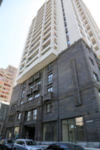 a tall building with cars parked in front of it at Seine Apartment by Downtown Inn, City Center in Yerevan