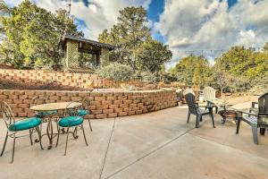 a patio with tables and chairs and a brick wall at Hike & Stargaze! Pet-Friendly Tonto Forest Studio in Payson