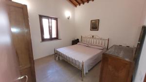 een kleine slaapkamer met een bed en een raam bij Agriturismo Poggio la Lodola in Massa Marittima