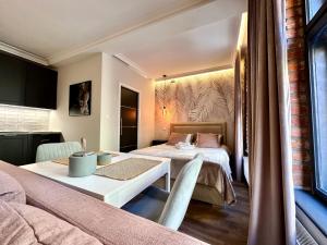 a room with two beds and a table with a table at PasteLove Okna in Toruń