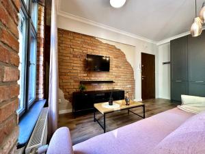 a living room with a brick wall and a table at PasteLove Okna in Toruń