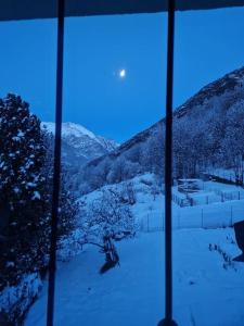 una ventana con vistas a una montaña nevada en da Annette rifugio montano, en Villaretto