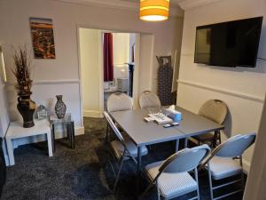 uma sala de jantar com uma mesa e cadeiras e uma televisão em Grange Villa Amethyst 3 Bed House near Chester le Street, sleeps 6 Guests em Chester-le-Street