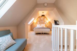 a attic bedroom with a bed and a staircase at Hôtel Échappée en Baie - Chambres climatisées -Parking privé gratuit dont forfaits bornes électriques réservable in Saint-Valéry-sur-Somme