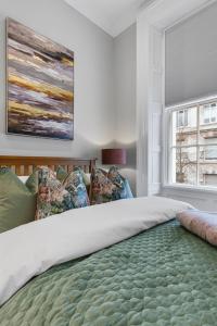 a bedroom with a large bed with a painting on the wall at Wilton House Belfast Serviced Apartments in Belfast