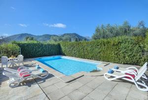 a swimming pool with two lawn chairs and a table and two chairs at Owl Booking Villa Can Gorreta - 5 Min Walk To The Old Town in Pollença