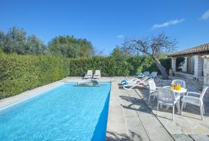 a swimming pool with chairs and a table next to a house at Owl Booking Villa Can Gorreta - 5 Min Walk To The Old Town in Pollença