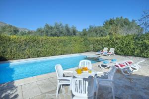a patio with a table and chairs next to a pool at Owl Booking Villa Can Gorreta - 5 Min Walk To The Old Town in Pollença